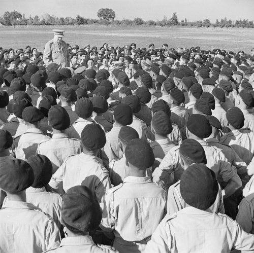 Winston Churchill delivers an informal speech to men of his old regiment, the 4th Queen's Own Hussars, at Loreto aerodrome in Italy, 25 August 1944.