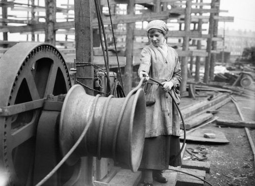 A female worker operates a winch at a shipbuilding yard on the River Clyde in Scotland during the First World War.