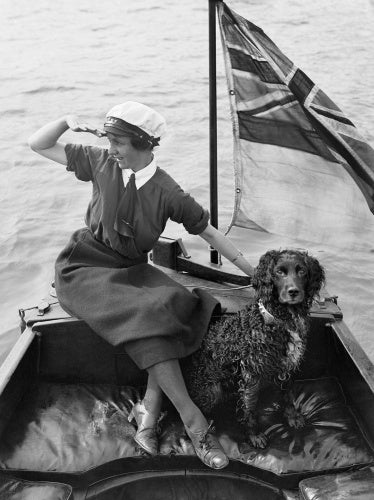 Gladys Wilburn, a motor boat driver with the Women's Royal Naval Service, in her boat, the 'BALMACAAN', with her spaniel dog, Southwick, Sussex, 1918.