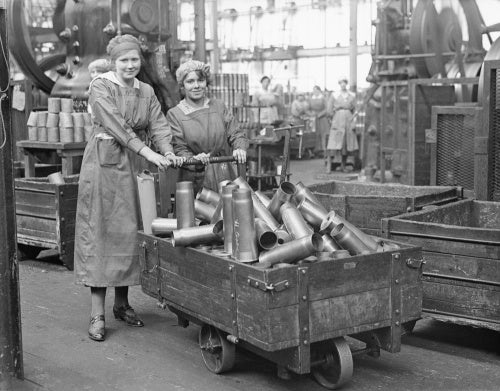 Two women munitions workers with a truck load of shell cases in the New Case Shop at the Royal Arsenal, Woolwich during the First World War.