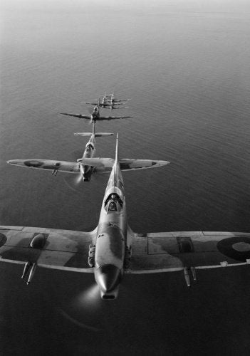 Supermarine Spitfire Mark VCs of No. 2 Squadron SAAF based at Palata, Italy, flying in loose line astern formation over the Adriatic Sea while on a bombing mission to the Sangro River battlefront.