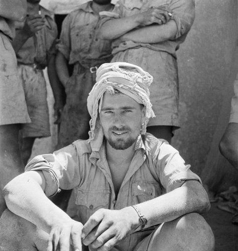 A soldier of the Long Range Desert Group uses a Libyan  keffiyeh scarf to protect his head from the sun, Siwa, Libya, 1942
