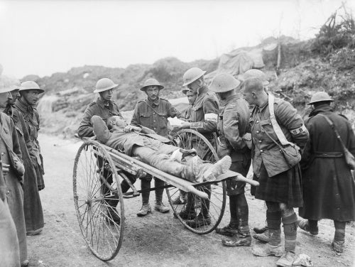 Battle of Bazentin Ridge. An intelligence officer questioning a wounded German prisoner on a stretcher near Contalmaison, Somme, July 1916.